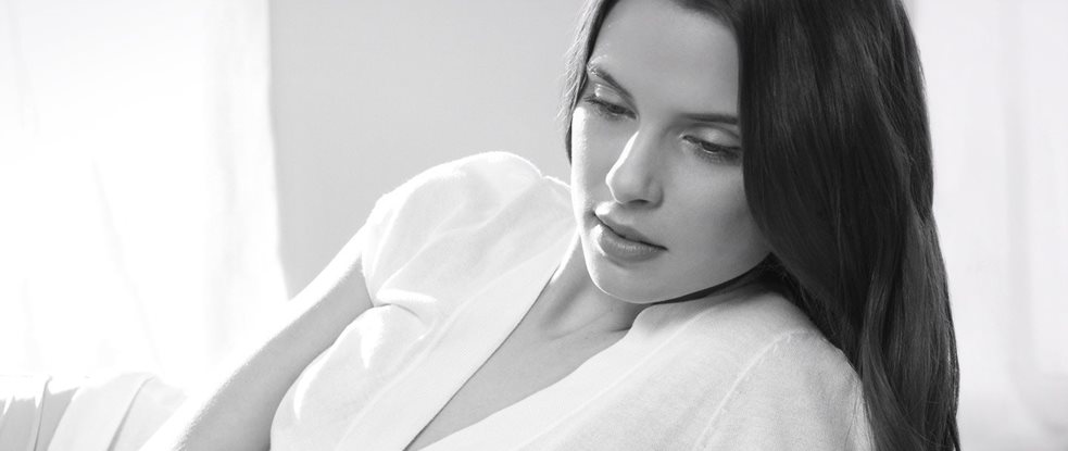 Egy nyugodt pózban lévő, sötét hajú nő