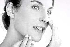 Nő ken fel krémet az arcára.