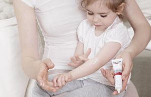 Kislány Eucerin terméket ken fel bőrére