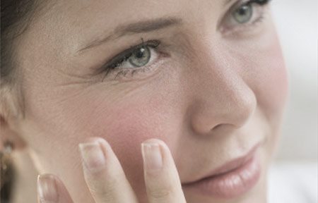 Arcát a kezével megérintő nő