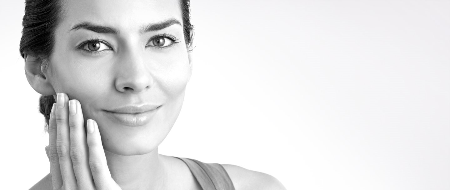 Arcának jobboldalát megérintő középkorú nő