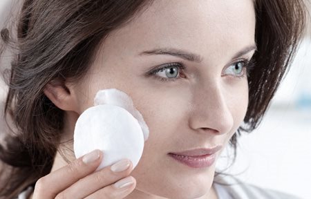 Arcát vattakoronggal tisztító nő