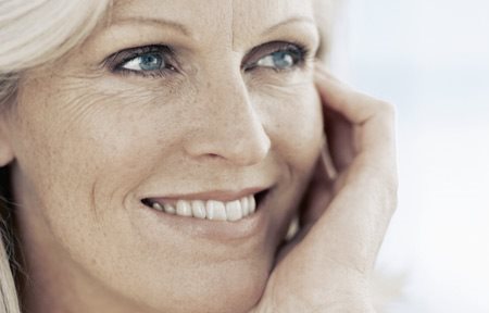 Középkorú nő mosolyog.